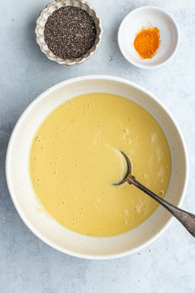 The mango, milk and maple syrup in a mixing bowl.