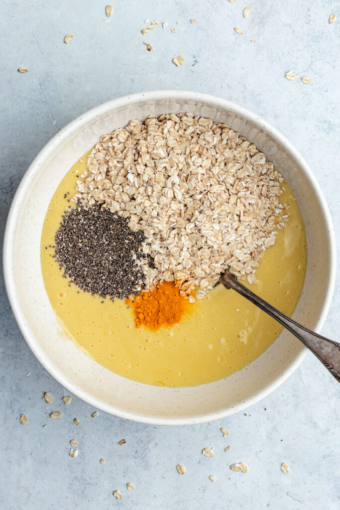 The added oats, chia seeds and turmeric in the mixing bowl.