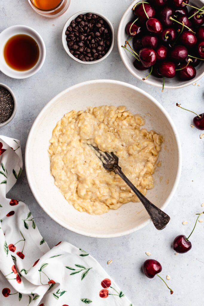 The mashed banana in a bowl with a fork.