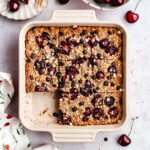 The baked oatmeal in the baking dish, cut into pieces.
