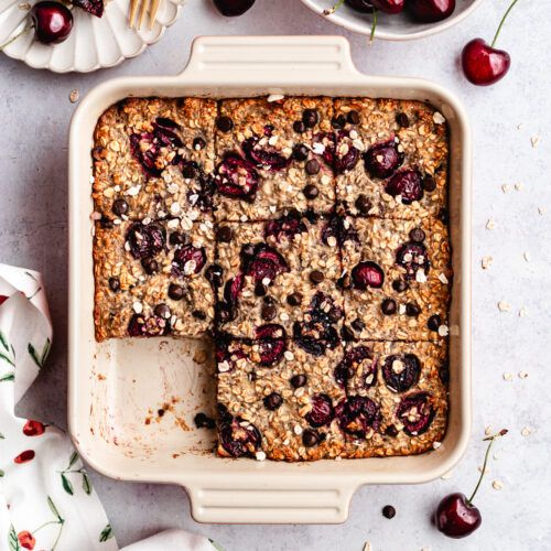 The baked oatmeal in the baking dish, cut into pieces.