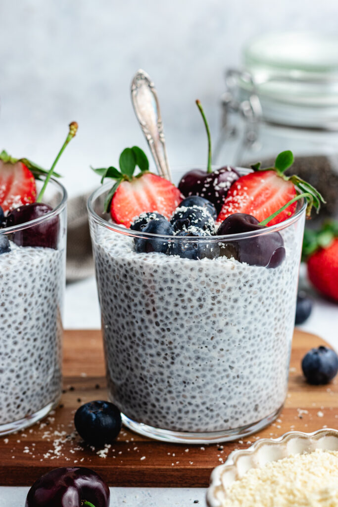 The chia pudding in to glasses topped with fresh berries and shredded coconut.