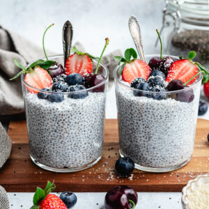 The chia pudding in to glasses topped with fresh berries and shredded coconut.