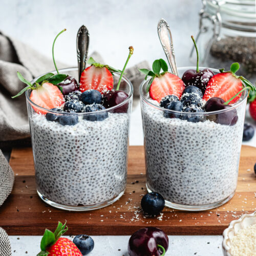 The chia pudding in to glasses topped with fresh berries and shredded coconut.