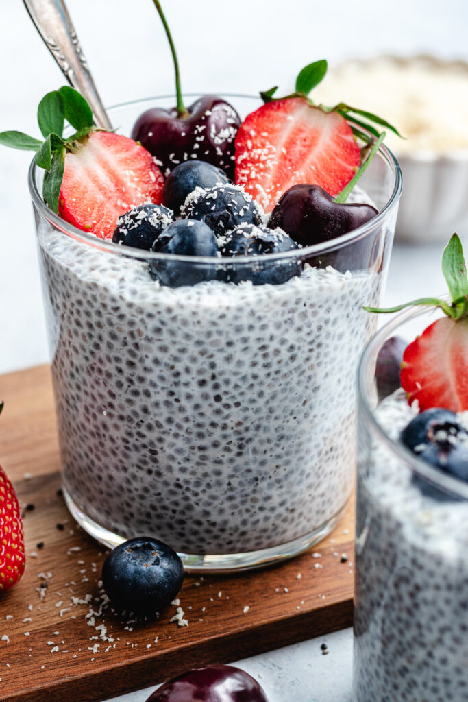 The chia pudding in to glasses topped with fresh berries and shredded coconut.