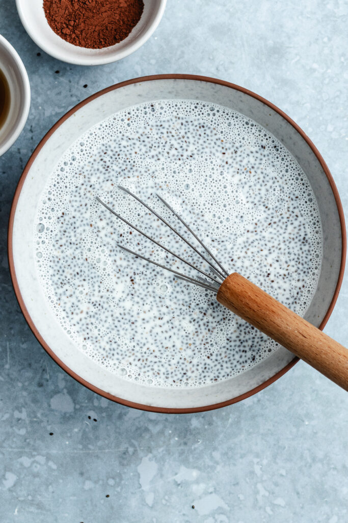 The chia pudding in a bowl with a whisk.