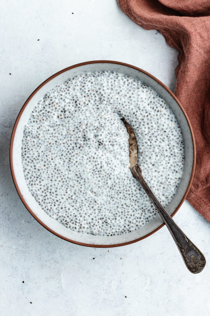 The chia pudding in a bowl with a spoon.