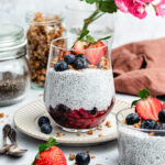 Vanilla chia pudding in a glass with berries and granola.