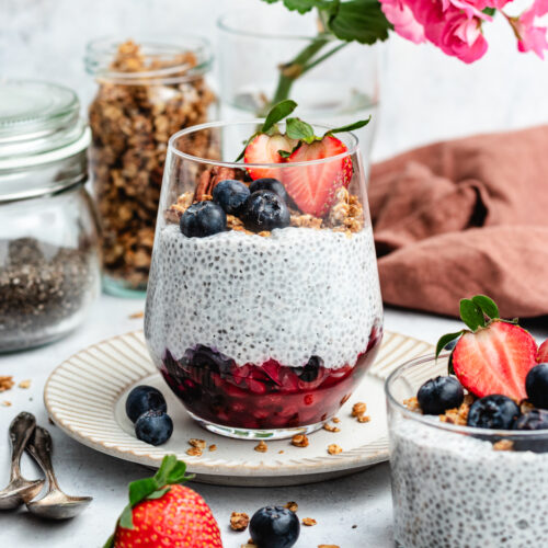 Vanilla chia pudding in a glass with berries and granola.