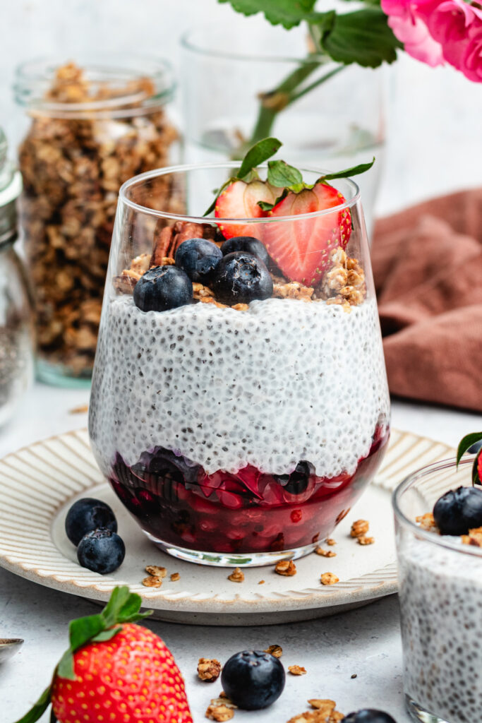 Vanilla chia pudding in a glass with berries and granola.