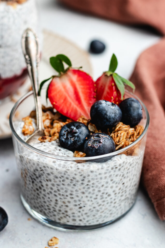 Vanilla chia pudding in a glass with berries and granola.