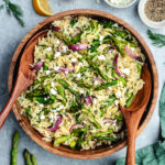 The salad in a bowl topped with fresh dill and feta cheese.