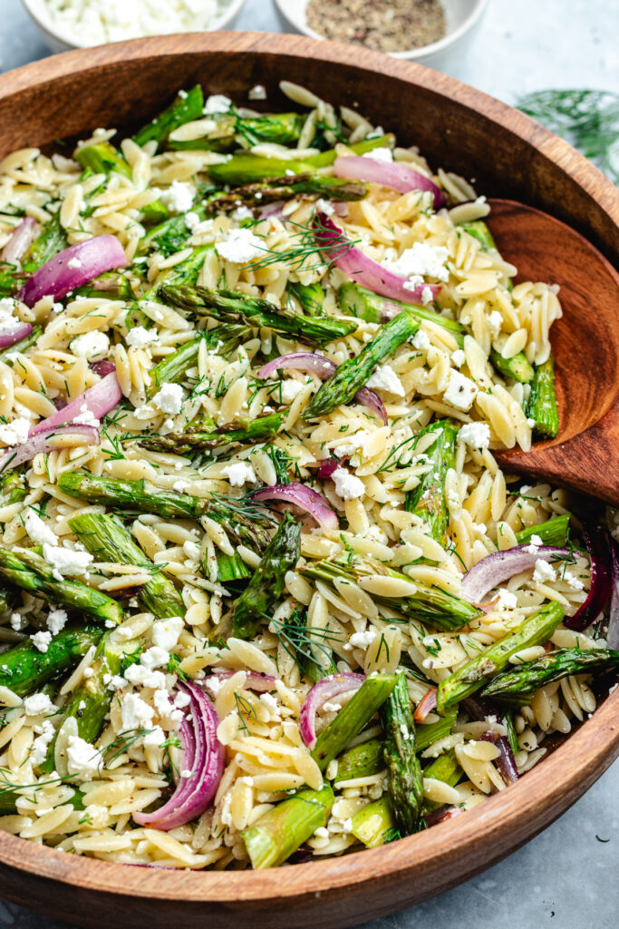 The salad in a bowl topped with fresh dill and feta cheese.