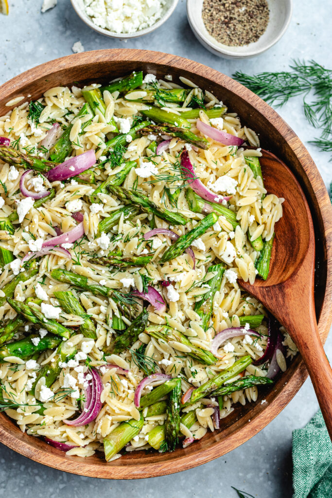 The salad in a bowl with a spoon, topped with fresh dill and feta cheese.