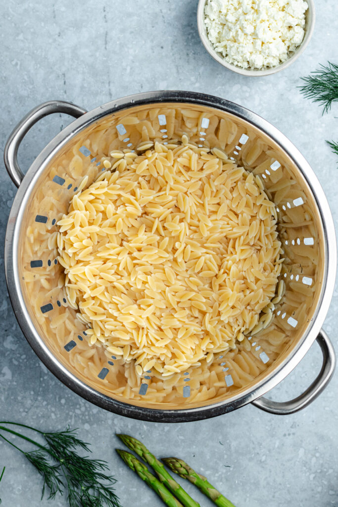 The cooked and drained orzo in a colander.