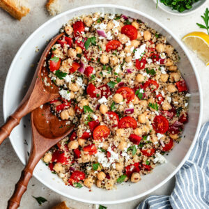 The salad in a large salad bowl with bread on the side.