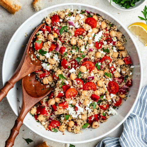 The salad in a large salad bowl with bread on the side.