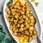 The roasted dill potatoes on a serving platter topped with fresh dill.