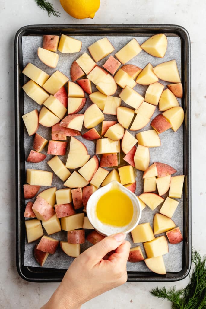The chopped potatoes on a baking sheet with melted butter.