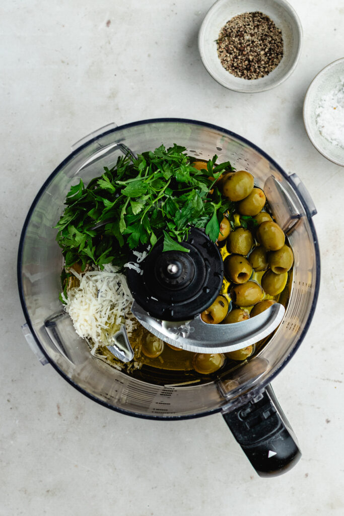 The ingredients for the olive dressing in a food processor.