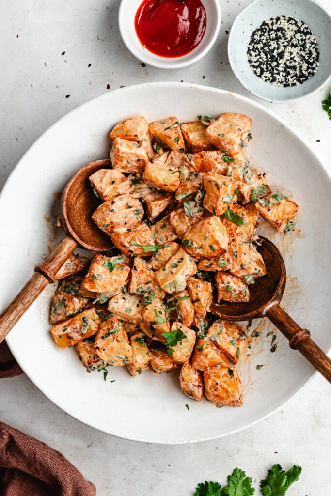 The potato salad in a bowl after being tossed with the dressing.