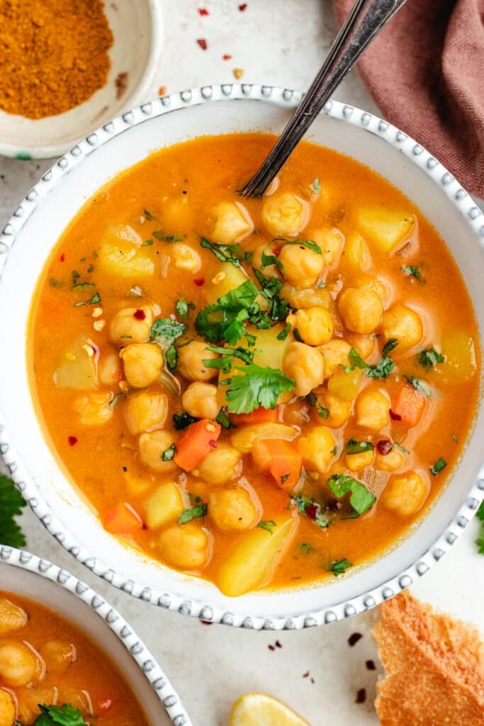 The soup in two bowls topped with fresh herbs.