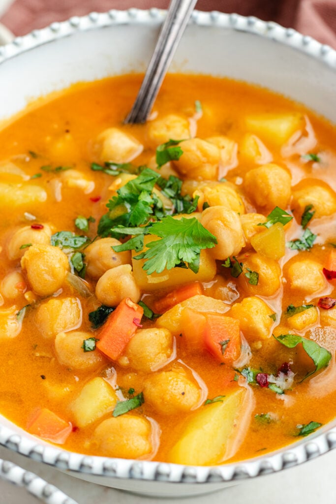 The soup in two bowls topped with fresh herbs.