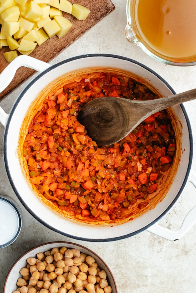 The sautéed veggies and tomato paste in a Dutch oven.