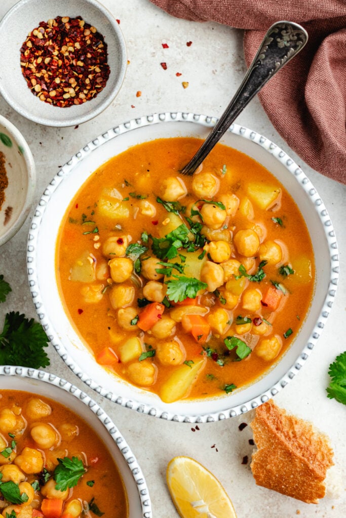 The soup in two bowls topped with fresh herbs.