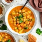 The soup in two bowls topped with fresh herbs.