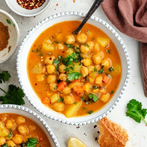 The soup in two bowls topped with fresh herbs.
