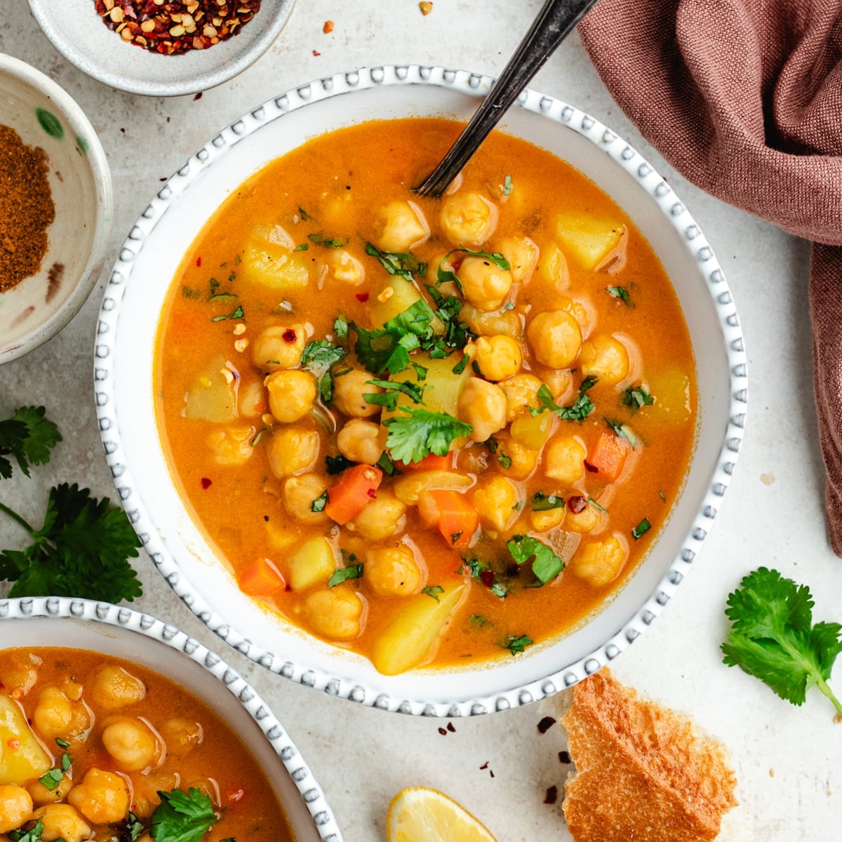 The soup in two bowls topped with fresh herbs.