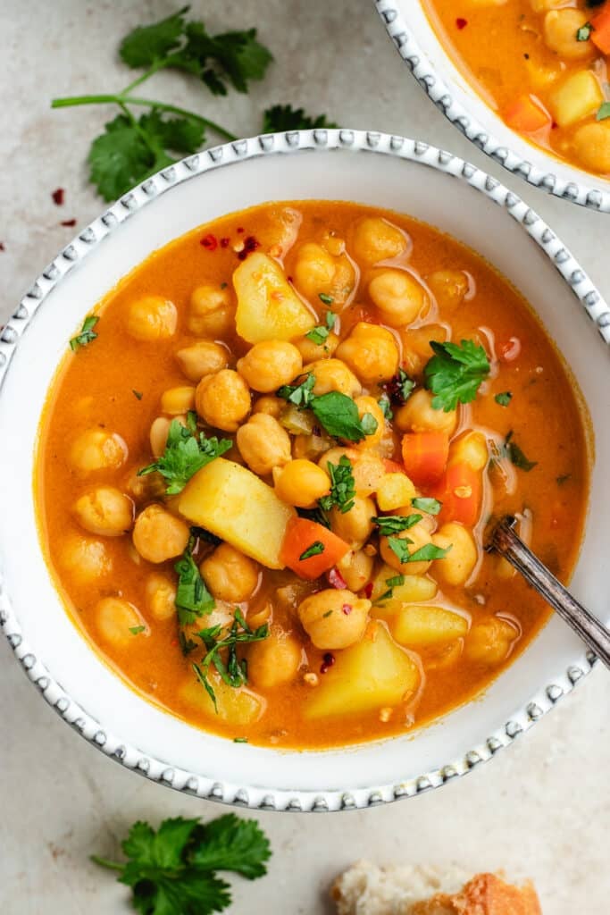 The soup in two bowls topped with fresh herbs. 