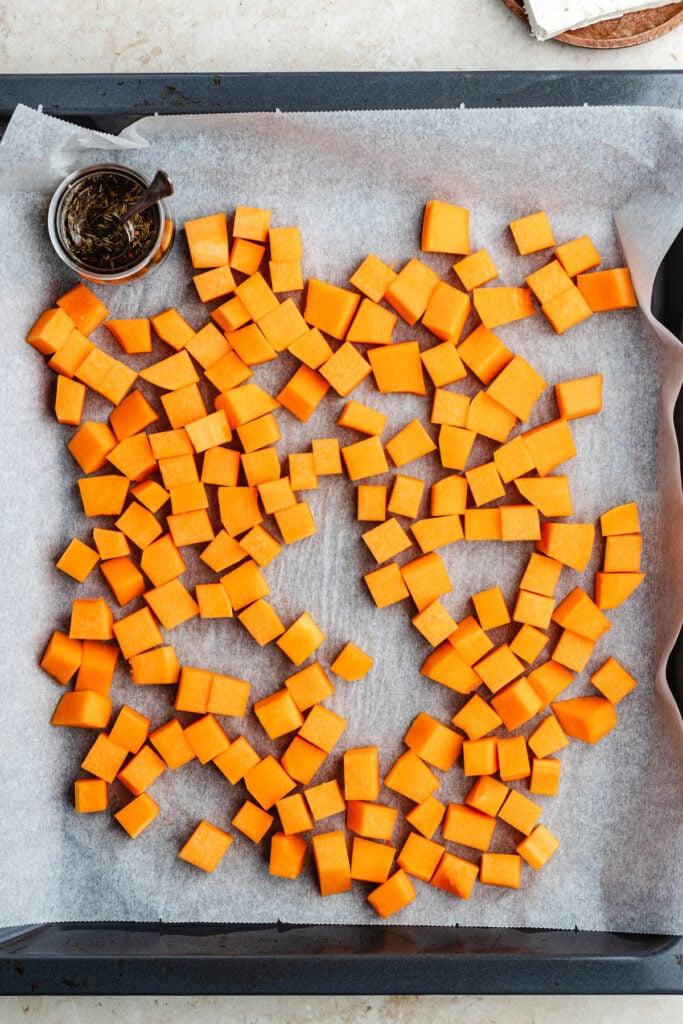 The chopped butternut squash on a baking tray.