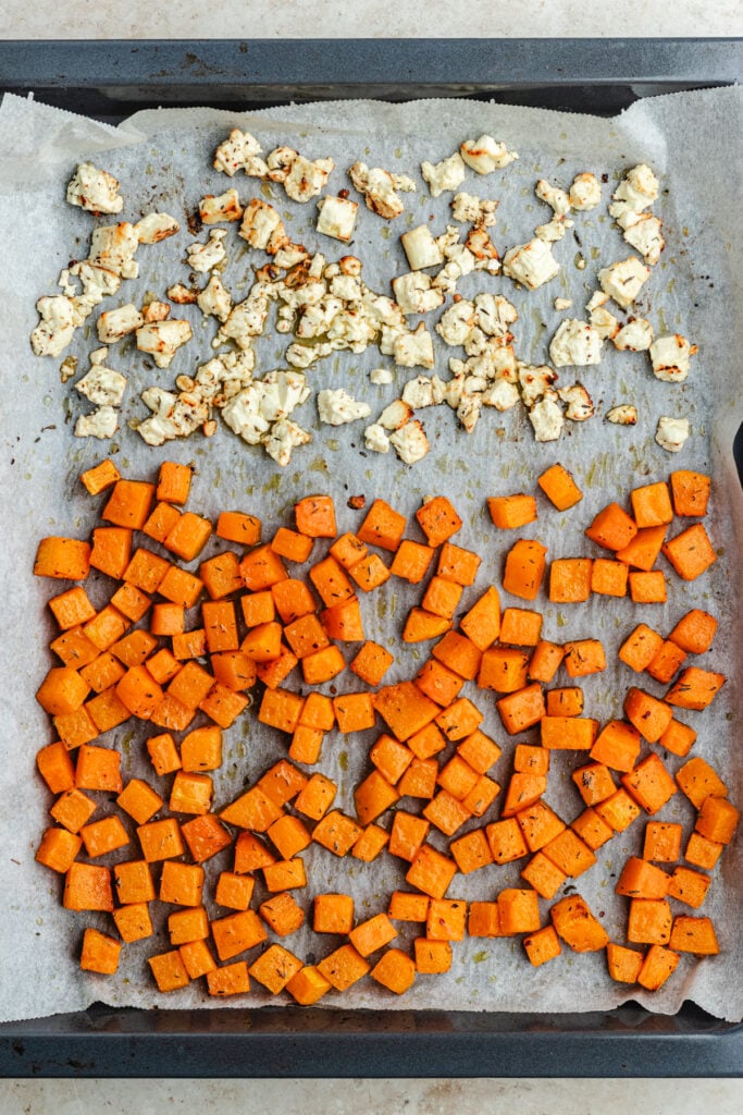 The roasted butternut squash and feta cheese on the baking tray.