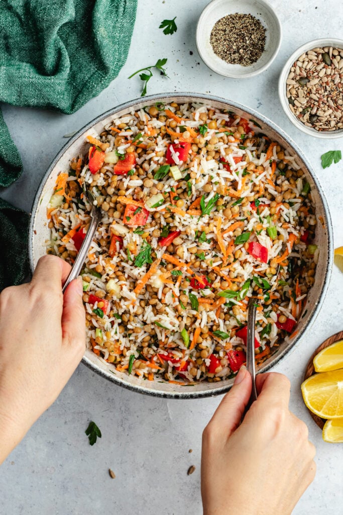 Tossing together the salad with two spoons.